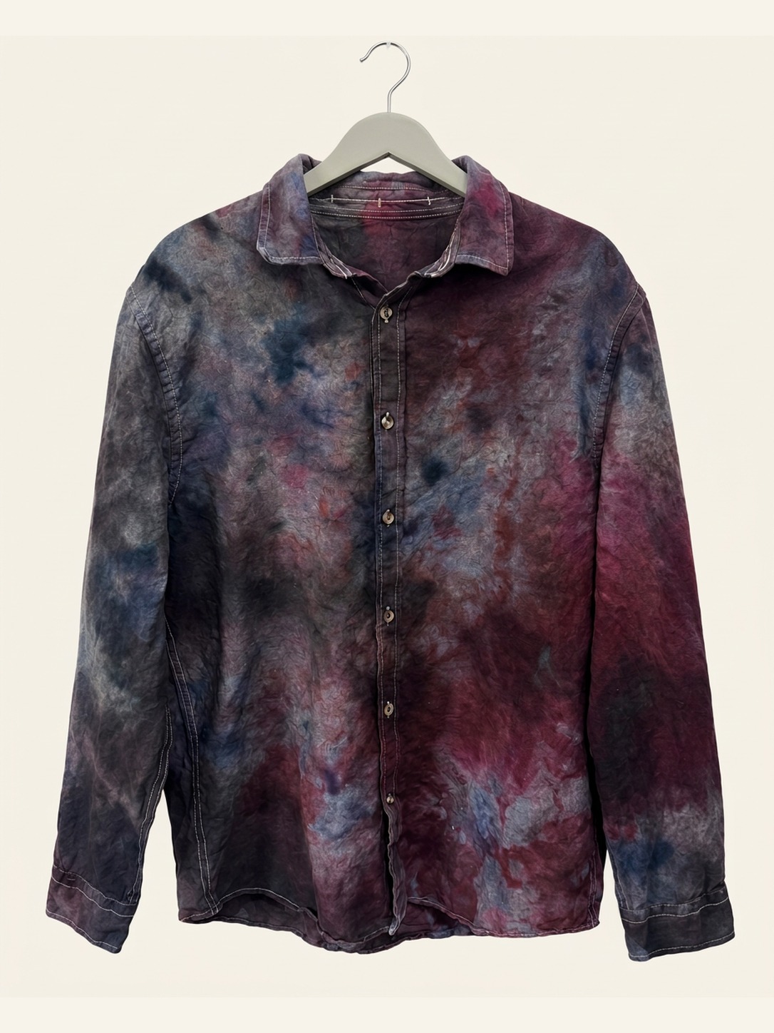 Hand ice-dyed cotton long-sleeve shirt in plum, maroon, indigo, and slate grey on a pale grey hanger