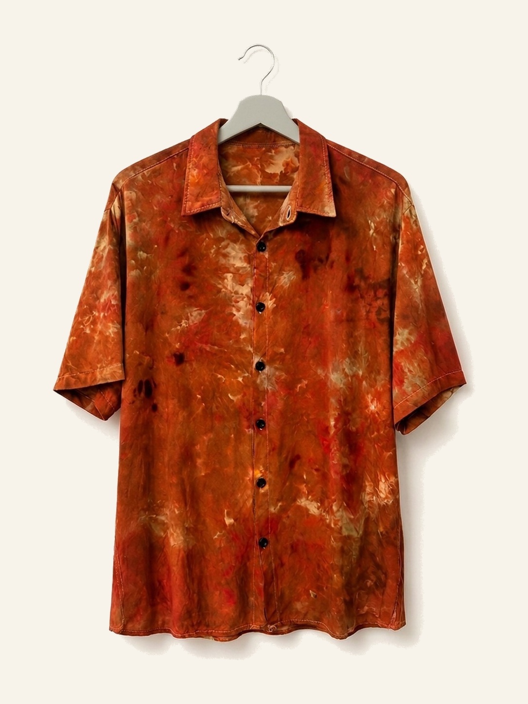 Hand ice-dyed bamboo shirt in rust, sand and orange on a wooden hanger